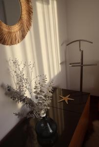 法鲁Sea View Apartment的花瓶,桌子上放着鲜花,还有镜子