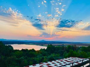 哈斯科沃Хижа Манастирчето-Книжовник的享有湖泊和建筑的日落美景