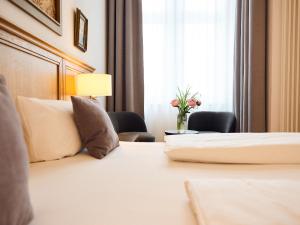 柏林林登乌法酒店的配有一张床和花瓶的酒店客房