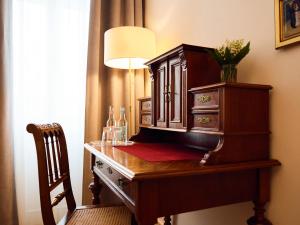 柏林林登乌法酒店的一张带台灯和椅子的木桌