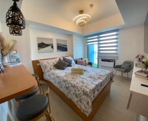圣费尔南多LeisureStay Studio @ Azure North的卧室配有一张床和一张桌子及椅子