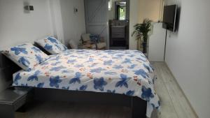 巴勒哈姆斯泰德B&B ZEEUWS KNOOPJE的一间卧室配有一张带蓝色花卉棉被的床