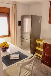 下布雷尼亚Mercedes (E): Campo y playa.的厨房配有冰箱和带一碗香蕉的桌子