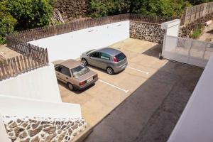 下布雷尼亚Mercedes (E): Campo y playa.的两辆汽车停在大楼旁边的停车场