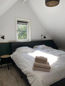 宁斯佩特Luxe Vakantiehuis Vosje op de Veluwe Nunspeet的一间卧室配有带毛巾的床