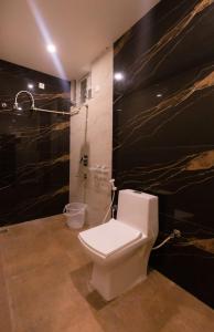 蒂鲁帕蒂Hotel Elite Park的浴室配有白色卫生间和淋浴。