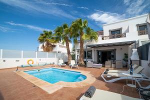 普拉亚布兰卡Villa Ariana Playa Blanca的一座别墅,设有游泳池和棕榈树