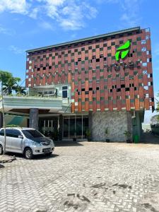 LubukpakamT HOTEL KUALANAMU的前面有停车位的建筑