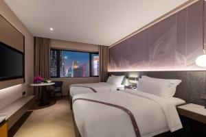 广州外商艺龙酒店（广州珠江新城店）的一间酒店客房,设有两张床和电视