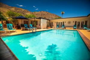 棕榈泉Old Ranch Inn - Adults Only 21 & Up的一个带椅子的游泳池以及一座房子