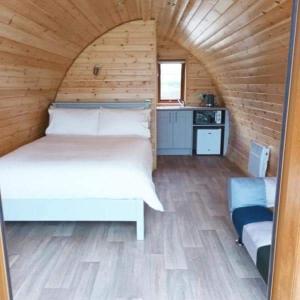 多尼戈尔Wheelhousepods glamping的木制客房内的一间白色床卧室