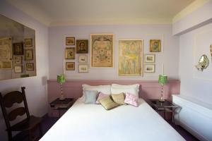 佛罗伦萨Stella d'Italia的卧室配有一张白色床,墙上挂有照片