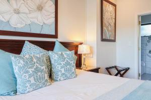 克尼斯纳琥珀宾馆的一间卧室配有一张带蓝色和白色枕头的床