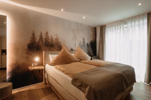 GerabronnBoutique Hotel Haus Marie的卧室配有一张大床,墙上挂有绘画作品