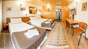 布加勒斯特Pensiunea Casa Verde Bucuresti的酒店客房配有两张床和一张书桌