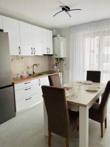谢林伯尔SNC Residence V的厨房配有桌椅和白色橱柜。