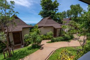 沙美岛Samed Tamarind Beach Resort的一座带花园和走道的房子
