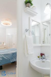银沙Sea Miracle Villa/Beach Cottage的白色的浴室设有水槽和一张床