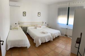 托莱多FINCA VALDELAJARA a 20 minutos de Puy du Fou的配有白色墙壁和瓷砖地板的客房内的两张床