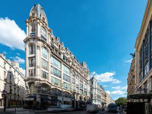 巴黎LivinParis - Luxury AC 2 & 3 Bedrooms Le Louvre的街道上一座白色的大建筑,钟楼