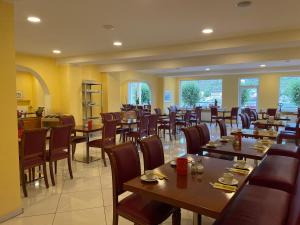 圣戈阿尔莱茵岩古堡酒店的餐厅设有木桌、椅子和窗户。