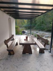 IgRiverside Guesthouse的天井上带2张长椅的野餐桌