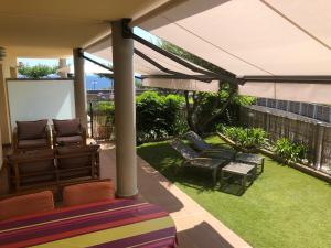 兰卡Apartament a les cales de Llançà en residència privada amb piscina的庭院设有椅子、遮阳伞和草地。