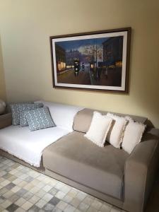 格拉瓦塔Chalé Refidim的一张带枕头的沙发和墙上的照片