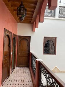 马拉喀什RIAD LAICHI的走廊设有两扇木门和楼梯