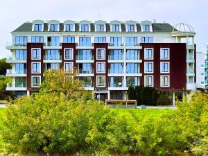 普里莫尔斯科Apart-Hotel Panorama Sea LUX的前面有长凳的大建筑