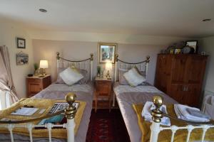 卡姆尔福德Melorne Farm Guest House的一间卧室设有两张单人床和一张桌子
