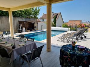 吕埃尔-马尔迈松Ravissant Studio avec parking privé et jardin的一个带桌椅的庭院和一个游泳池