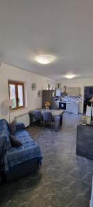 陶尔米纳La Casa di Angelina的一间带蓝色沙发的客厅和一间厨房