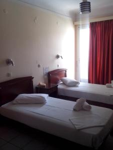 提诺斯Hotel Lito的酒店客房设有两张床和窗户。