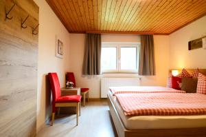 阿布特瑙拉梅雷霍夫旅馆的一间卧室配有一张床和一张红色椅子