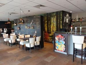 EwijkRumah Senang Ewijk met royale tuin en hottub的餐厅设有粉笔板墙、酒吧和椅子