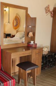 Misfāh密斯法老房子旅馆的一间卧室配有书桌和镜子
