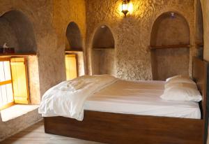 Misfāh密斯法老房子旅馆的卧室配有一张石墙床