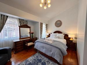 库斯科Hotel-Apartment INKASABIOS的一间卧室配有一张床、镜子和椅子