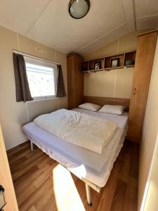 米德尔克尔克Stacaravan Middelkerke的小型客房设有一张单人床和窗户。