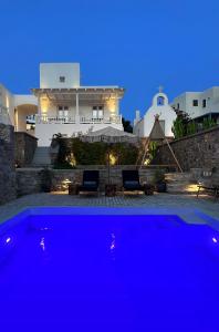 米克诺斯城Sofos Suites Mykonos的房子前面的蓝色游泳池