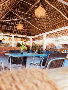 NdiziMalik Villa Matemwe的餐厅设有蓝色的桌椅和天花板。