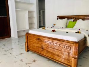 NdiziMalik Villa Matemwe的一间卧室配有带白色和绿色枕头的木床
