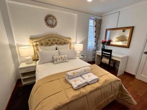 库斯科Hotel-Apartment INKASABIOS的一间卧室配有一张床,上面有两条毛巾