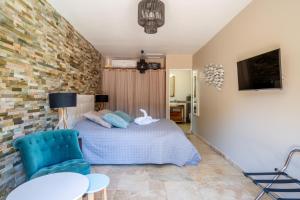 穆昂萨尔图Villa Golf les Cigales的一间卧室配有一张床和一张蓝色椅子