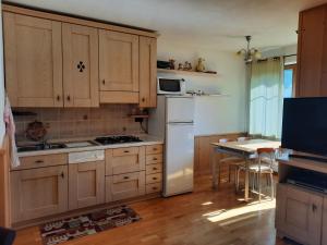 莫尔韦诺Appartamento la Regina del Lago的厨房配有木制橱柜和白色冰箱。
