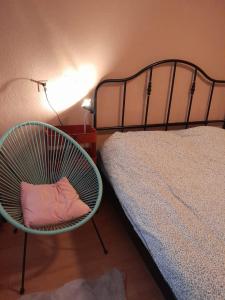 布尔坦赫城Achter de Vesting的一间卧室配有一张床和床边的椅子