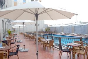 延布亚布宜必思酒店的游泳池旁的天井配有桌椅和遮阳伞。