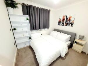 West Byfleet2 BEDROOM APT WITH 2 COMFORTABLE KING SIZE BEDs, FREE PRIVATE PARKING, EASY ACCESS TO LONDON的卧室配有白色的床和窗户。