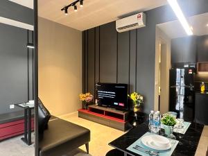 吉隆坡Axon Luxury Suites KL的一间带电视和桌子的客厅